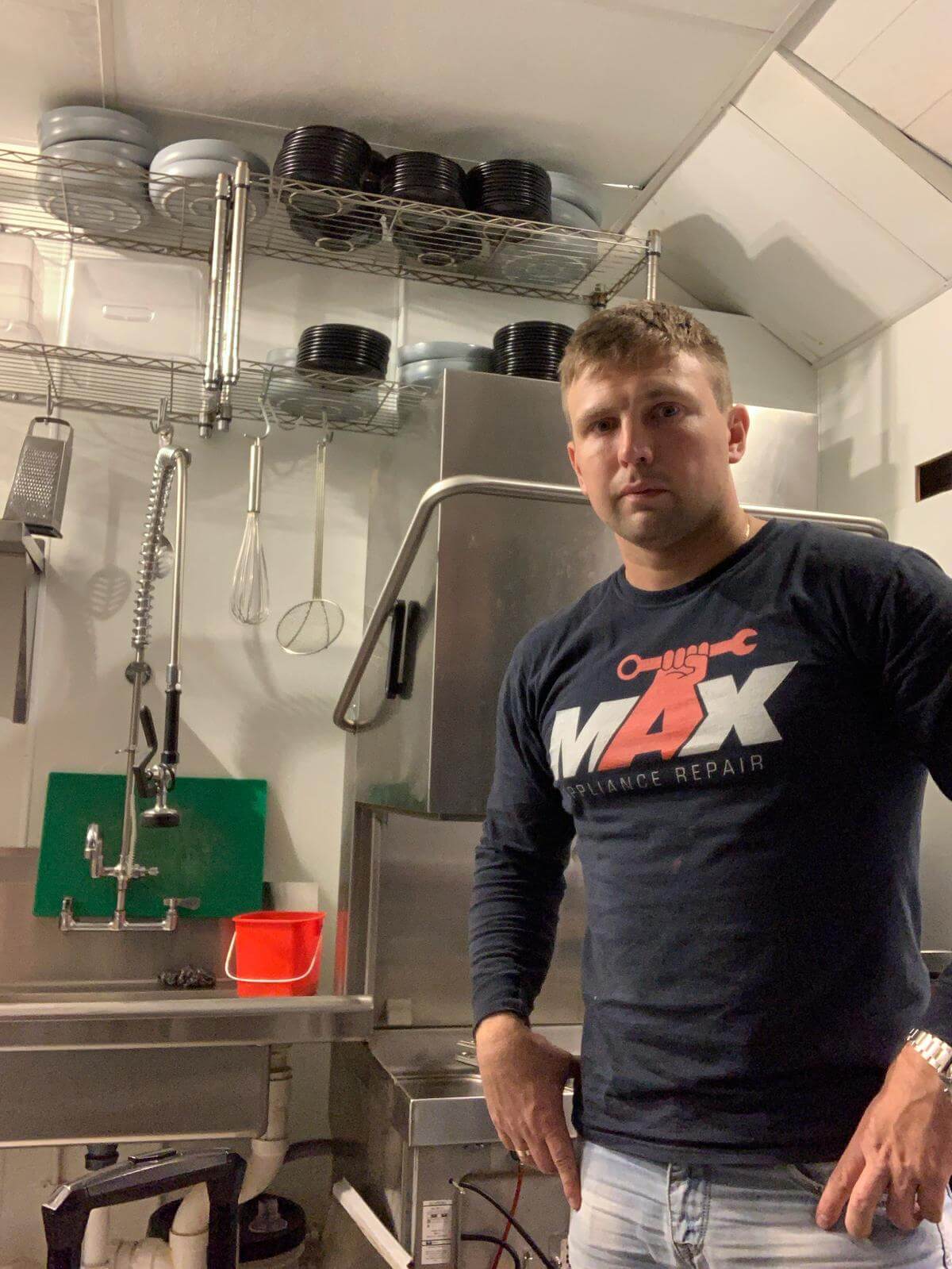 technician professionally repairing a commercial dishwasher