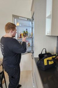 technician fixing fridge not cooling